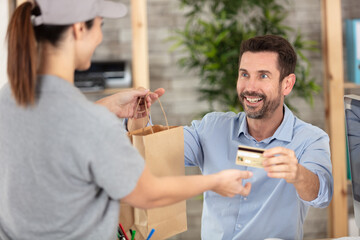 woman using terminal to pay courier for food delivery