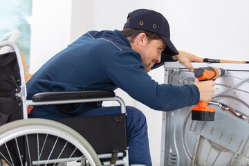 invalid working man plumber repairs a washing machine in laundry