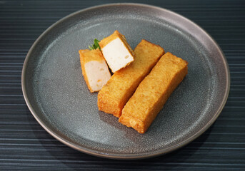 deep fried long golden stick salmon fish seafood paste cake on dark grey wood background dim sum halal menu