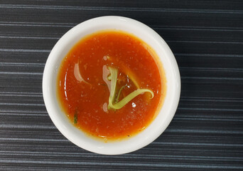 homemade garlic spicy chilli sauce in white plate on dark grey wood background dim sum halal menu