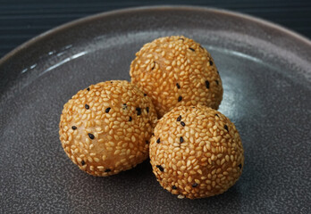 deep fried golden crispy sesame ball wrapped with sweet pandan lotus paste lava dessert on dark grey wood background dim sum menu