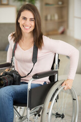 wheelchair bound woman at home holding a camera