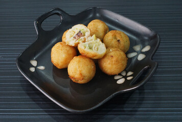 Japanese grilled takoyaki ball with octopus seafood in black plate on dark grey wood background dim sum halal menu
