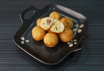 Japanese grilled takoyaki ball with octopus seafood in black plate on dark grey wood background dim sum halal menu