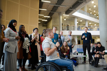 Fototapeta na wymiar Female speaker in wheelchair talking to audience