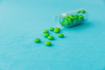 The pills are scattered on the table. Tablets on the blue background. Medicinal tablets, capsules, pills.