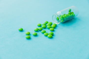 The pills are scattered on the table. Tablets on the blue background. Medicinal tablets, capsules, pills.