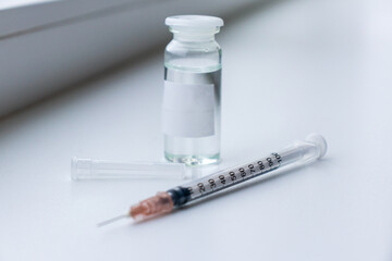 vaccine on a vial bottle and injection Syringe on a white table