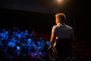 Fototapeta na wymiar Audience watching speaker in wheelchair talking on stage