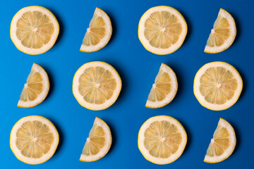 Cool summer pattern with lemon slices on blue background