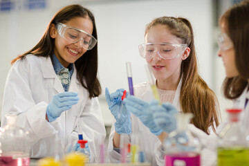 Girl students conducting scientific experiment in laboratory classroom