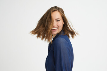 Portrait of a young happy woman in motion smiling on white background