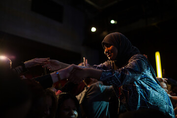 Audience reaching for female speaker in hijab
