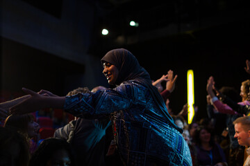 Fototapeta na wymiar Audience reaching for female speaker in hijab