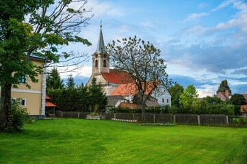 Fototapeta na wymiar Building, old church, tree and meadow in garden in small village Hurky.
