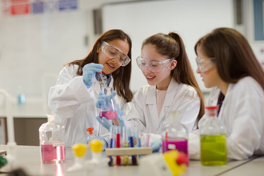 Girl students conducting scientific experiment in laboratory classroom