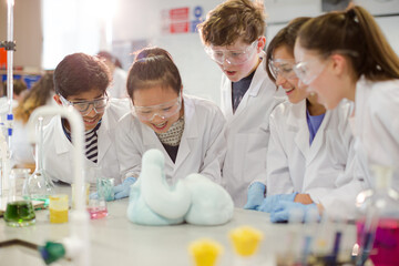 Surprised students conducting exploding foam scientific experiment in classroom laboratory