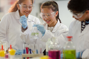Students watching chemical reaction, conducting scientific experiment in laboratory classroom