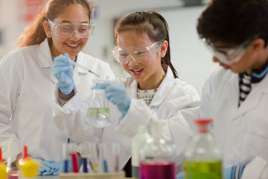 Students watching chemical reaction, conducting scientific experiment in laboratory classroom
