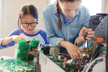 Girl students assembling computer in classroom