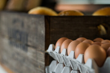 Rustic, economy carton of free range, organic eggs next to a box of bread 