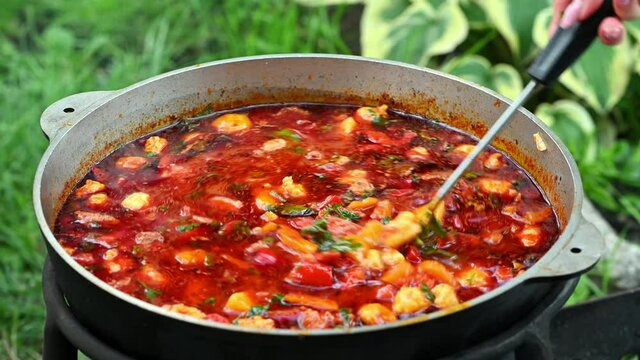 Hungarian traditional bograch. Making stew on open fire. german comfort food. Traditional Hungarian Goulash in cauldron. Transcarpathian dish. Soup with meat and paprika. Eintopf, chili con carne.