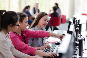 Girl students using computer in library