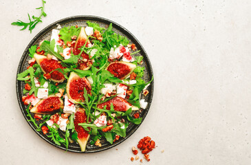 Sweet fig salad with soft goat cheese, walnuts, arugula and jam dressing on white background, top...