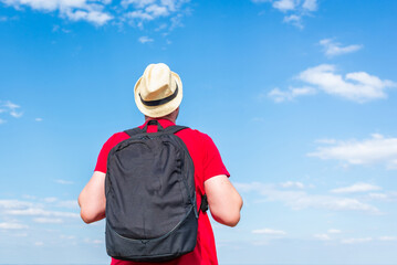 Young man admiring beautiful view of the forest landscape rear view.Young man standing alone summer day outdoors.