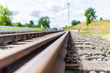 Obraz premium Railway track details closeup photo with selective focus.Close-up view of railway bolts.Summer day details of railway