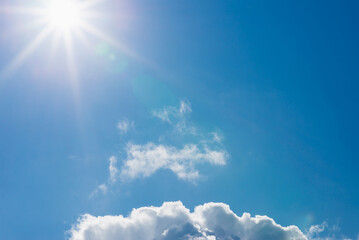 Naklejka na ściany i meble Shining sun at clear blue sky,clouds.Solar lens flare. copy space.Natural lens flare.