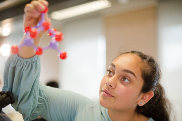 Curious girl student examining molecular structure