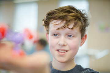 Curious boy examining molecule model in laboratory classroom