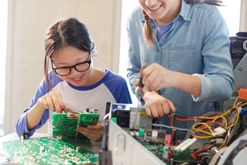 Girl students assembling computer in classroom