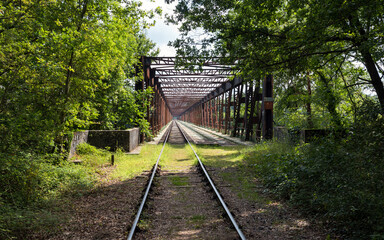 Old railway line crossing a rusty bridge turned into recreational track for rail-cycle draisine...