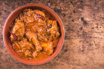 Hungarian chicken stew with paprika and sour cream - chicken paprikash in bowl, top view, copy space