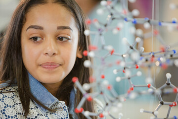 Portrait smiling girl student holding molecular model in laboratory classroom