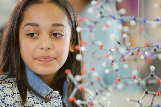 Portrait smiling girl student holding molecular model in laboratory classroom