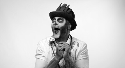 Frightening man in skeleton Halloween costume. Cunning guy in creepy skull makeup with tricky face...