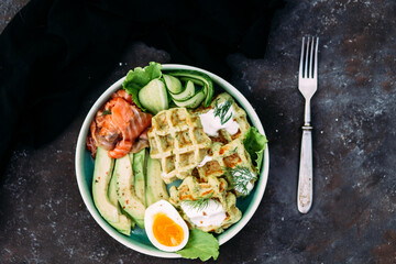 Belgian waffles with salmon, avocado and egg in a plate