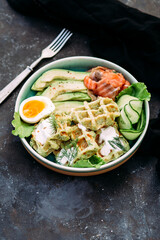Belgian waffles with salmon, avocado and egg in a plate