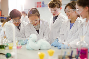 Surprised students conducting exploding foam scientific experiment in classroom laboratory