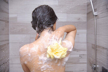 Back view of a beautiful woman taking a shower
