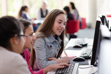 Girl students using computer in library