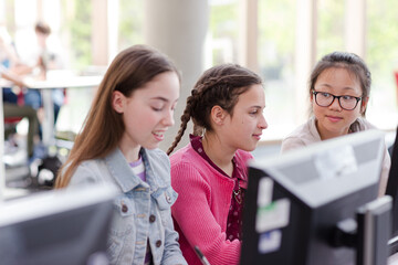 Girl students using computer in library