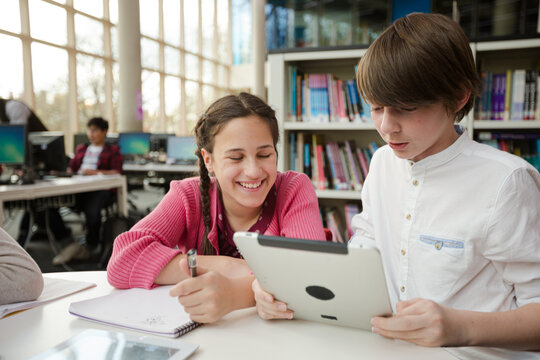 Students using digital tablet in library