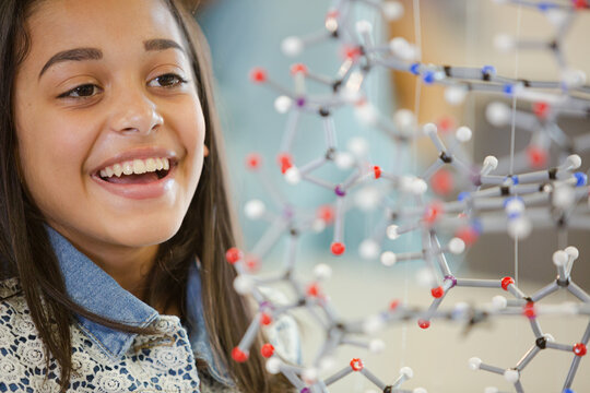 Portrait smiling girl student holding molecular model in laboratory classroom