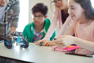 Students playing with robot in classroom