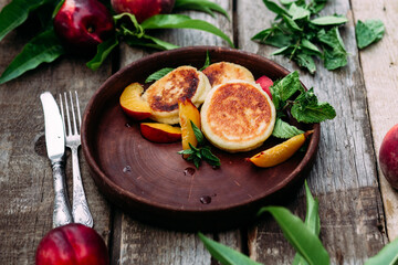 Sweet cheesecakes with peach in a plate close-up. Breakfast