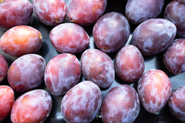 Top view of ripe plums on a black background 